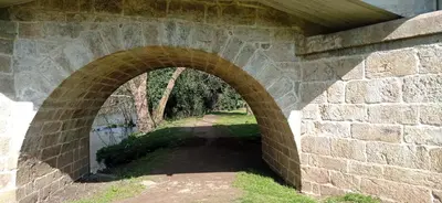 a stone bridge with an arch over a river at O Refuxio de Sigüeiro # a 10 min de Santiago in Sigüeiro