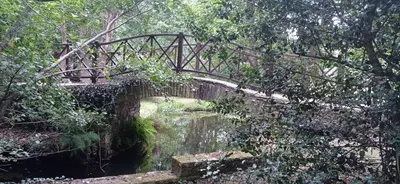 a bridge over a river in a park at O Refuxio de Sigüeiro # a 10 min de Santiago in Sigüeiro