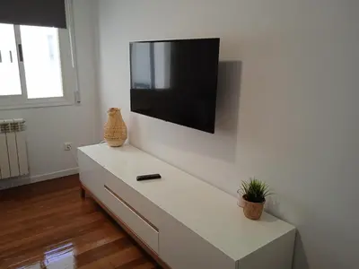 a white dresser with a flat screen tv on a wall at O Refuxio de Sigüeiro # a 10 min de Santiago in Sigüeiro