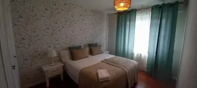 a bedroom with a bed with green curtains and a window at O Refuxio de Sigüeiro # a 10 min de Santiago in Sigüeiro