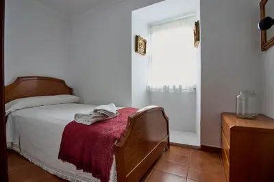 a bedroom with a bed with a red blanket and a window at Casa de Mila en Creciente Pontevedra in Crecíente