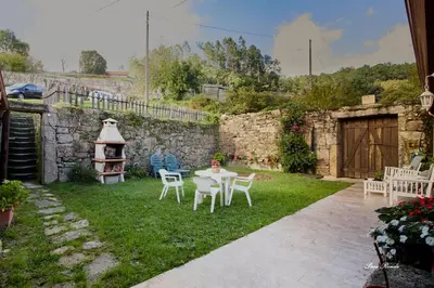 a patio with a table and chairs in a yard at Casa de Mila en Creciente Pontevedra in Crecíente