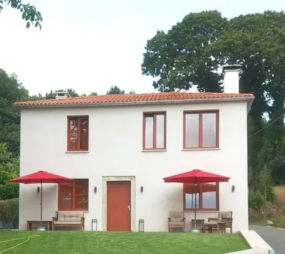 a white house with red umbrellas in front of it at Casa do Crego in Brañas