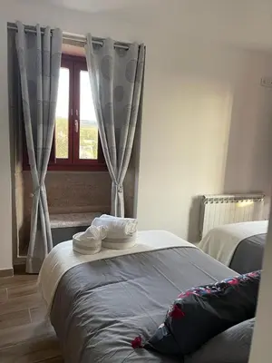 a bedroom with a bed and a window with curtains at Casa do Crego in Brañas