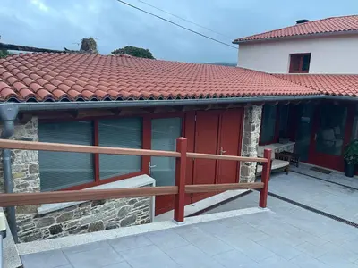 a house with red doors and a wooden fence at Casa do Crego in Brañas