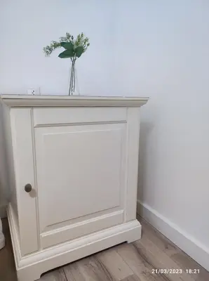 a white console table with a vase of flowers on it at Casa Dina in Carballino