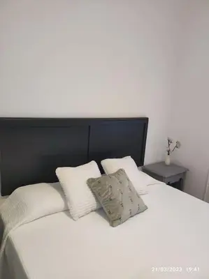 a white bed with a black headboard and two pillows at Casa Dina in Carballino