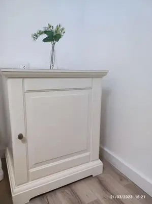 a white console table with a vase of flowers on it at Casa Dina in Carballino