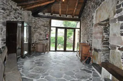 a room with a stone wall and a stone floor at A Horta de Abel in Tríacastela