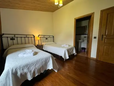 a hotel room with two beds and a bathroom at A Horta de Abel in Tríacastela