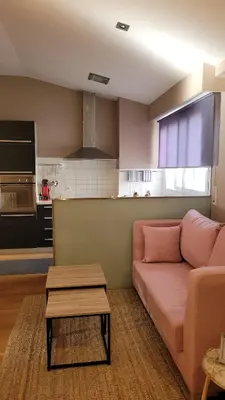 a living room with a couch and a kitchen at Paz Termal in Ourense