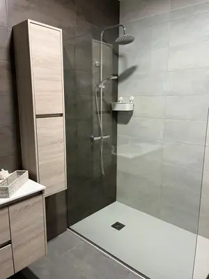 a shower with a glass door in a bathroom at Fogar de Aurora in Portomarin