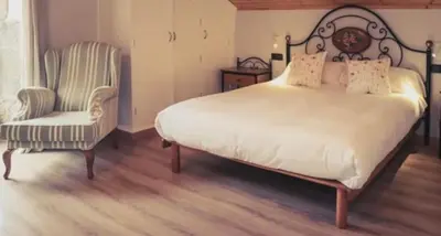 a bedroom with a large bed and a chair at O Lagoeiro in A Estrada