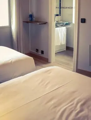 a bedroom with two white beds and a mirror at O Lagoeiro in A Estrada