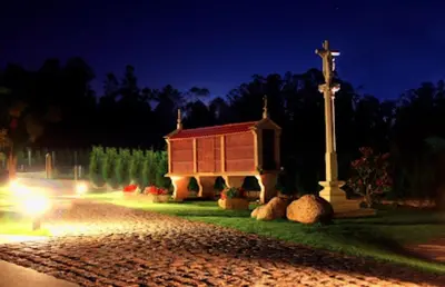 a small church with a cross and a pole at O Lagoeiro in A Estrada