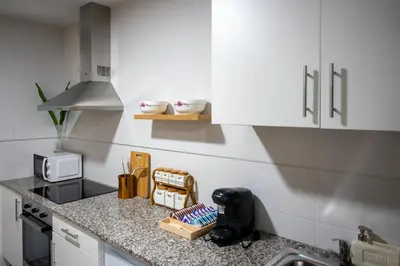 a kitchen with white cabinets and a counter top at FondeRiviere in Caldas de Reis