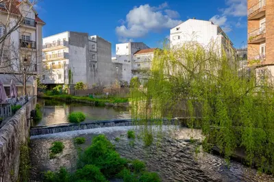a river in the middle of a city with buildings at FondeRiviere in Caldas de Reis