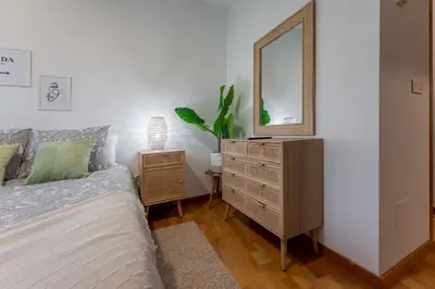 a bedroom with a bed and a dresser with a mirror at FondeRiviere in Caldas de Reis