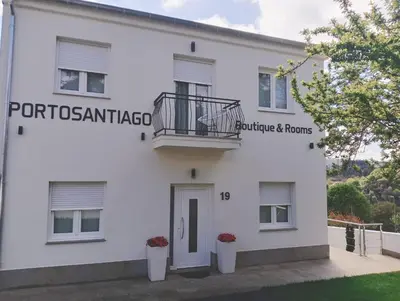 a white building with a balcony on the side at PortoSantiago Boutique & Rooms in Portomarin