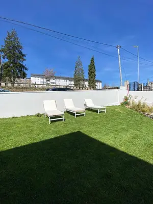 two white chairs sitting on the grass in a yard at PortoSantiago Boutique & Rooms in Portomarin