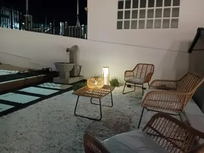 a patio with chairs and a table and a lamp at PortoSantiago Boutique & Rooms in Portomarin