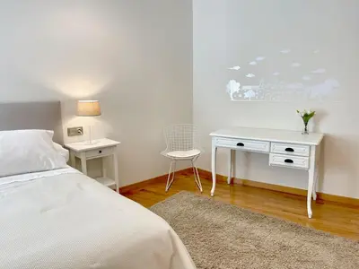 a bedroom with a white desk and a bed at The Cliffs - Montmar in Viveiro