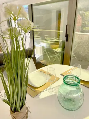 a table with wine glasses and a vase on it at The Cliffs - Montmar in Viveiro