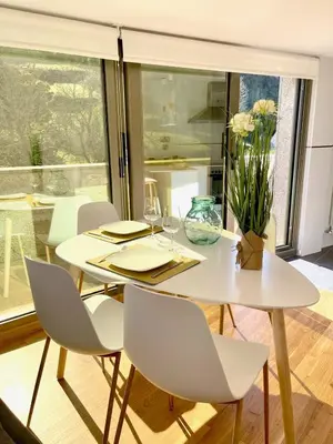 a white dining room with a white table and chairs at The Cliffs - Montmar in Viveiro