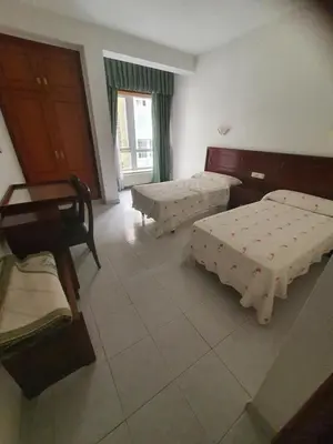 a room with two beds and a table in it at Flor de Loto in Ordes