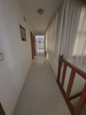 a long hallway with white walls and a window at Flor de Loto in Ordes