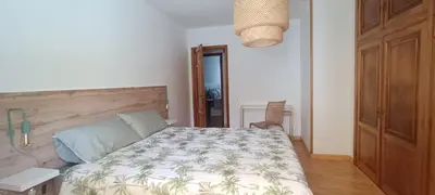 a bedroom with a bed with a wooden headboard at Casa Vilas, Santiago de Compostela in Santiago de Compostela