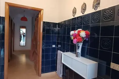 a blue tiled hallway with a vase of flowers on a counter at Casa Vilas, Santiago de Compostela in Santiago de Compostela