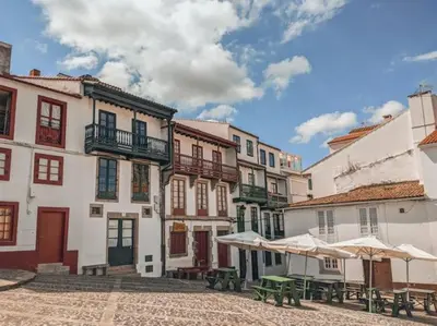 a group of buildings with tables and umbrellas in a courtyard at Casa típica Betanzos Casco Histórico in Betanzos
