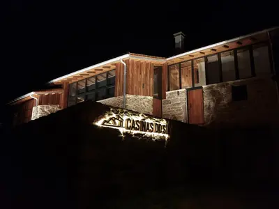 a sign on the side of a building at night at Casiñas do Sil in Cristosende