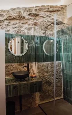 a bathroom with a sink and two mirrors at Casiñas do Sil in Cristosende
