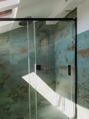a glass shower in a room with a wall at Casiñas do Sil in Cristosende
