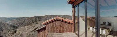a glass building with a view of a mountain at Casiñas do Sil in Cristosende