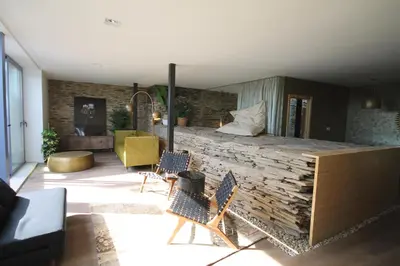 a room with two chairs and a stone wall at Hotel Casas da Fortaleza in Lugo