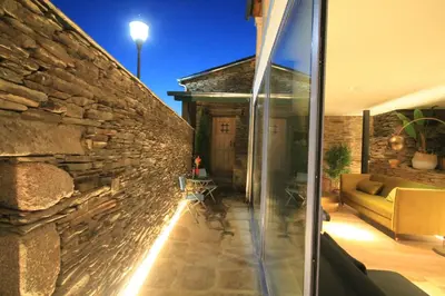 a house with a stone wall and a glass door at Hotel Casas da Fortaleza in Lugo