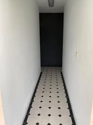 a hallway with a black door and a black and white tiled floor at Viviendas uso turístico REME II in Foz