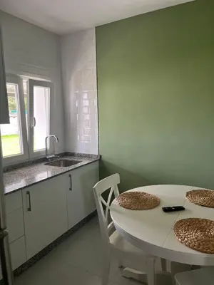 a kitchen with a white table and chairs and a sink at Viviendas uso turístico REME II in Foz