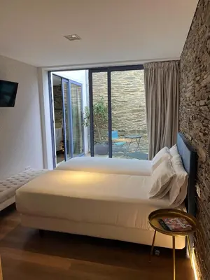 a large bed in a room with a large window at HOTEL CASAS DA FORTALEZA Casa da Muralla in Outeiro de Rei