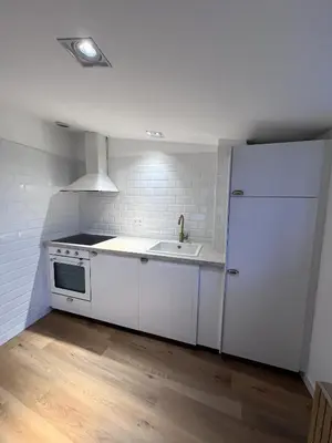 a white kitchen with a sink and a refrigerator at HOTEL CASAS DA FORTALEZA Casa da Solaina in Outeiro de Rei