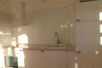 a white kitchen with a sink and a refrigerator at HOTEL CASAS DA FORTALEZA Casa da Solaina in Outeiro de Rei