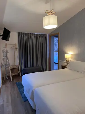 a bedroom with a large white bed and a window at HOTEL CASAS DA FORTALEZA Casa da Solaina in Outeiro de Rei