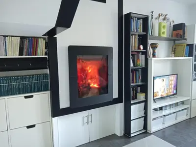 a fireplace in a living room with a book shelf at Abrigadoiro de Rexa in Barreiros