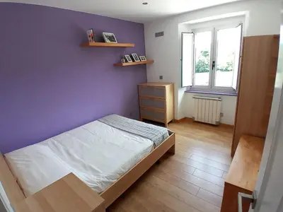a bedroom with a bed and a purple wall at Abrigadoiro de Rexa in Barreiros