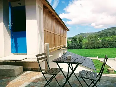 a patio with two chairs and a table on a building at Abrigadoiro de Rexa in Barreiros