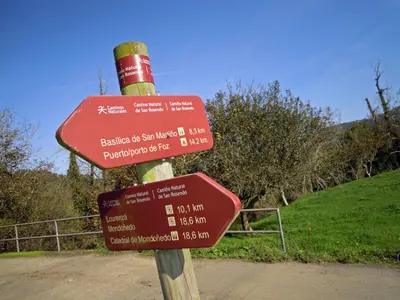 a wooden pole with signs on a road at Abrigadoiro de Rexa in Barreiros