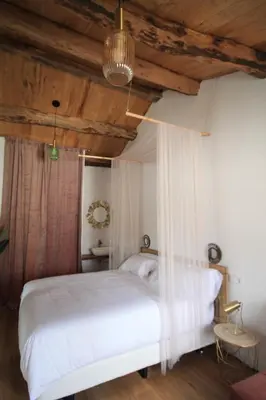 a bedroom with a white bed and wooden ceilings at HOTEL CASAS DA FORTALEZA Casa do Garda in Outeiro de Rei